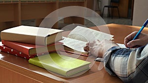 A man leads entries in a notebook sitting at the table in the office