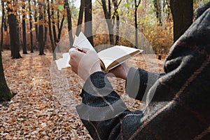 Man leafing through open book in forest