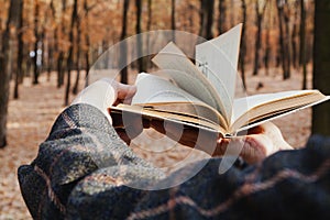 Man leafing through open book in forest