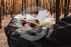 Man leafing through open book in forest