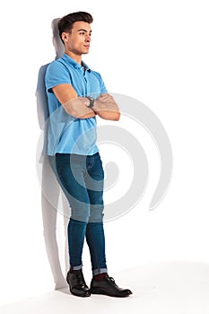 Man leaning against studio wall with hands crossed