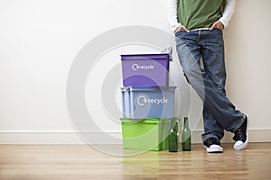 Man Leaning Against Wall By Recycling Containers