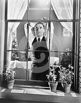 Man leaning against a window while day dreaming