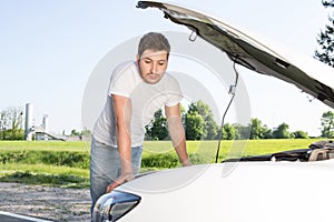 Man leaning on car with opened bonnet