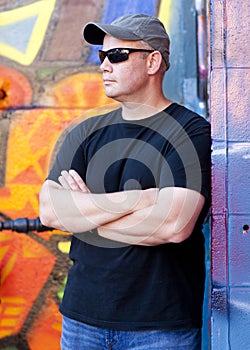Man leaning on grafitti wall