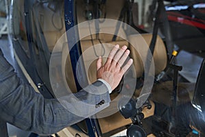 Man leaning one hand on helicopter cabin