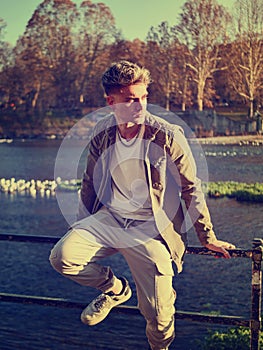 Man leaning on rail near body of water