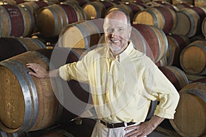 Man Leaning On Wine Cask In Cellar