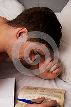 Man learning to exam in his bed.
