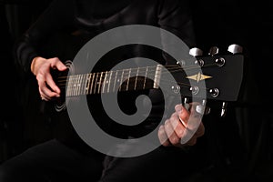 Male musician tuning the strings on the guitar