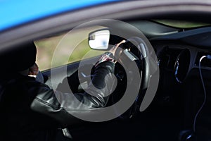 Man leather jacket driving sports car blue