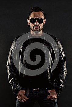 Man in leather jacket and jeans. Bearded man in trendy sunglasses. Fashion model in casual style clothes. Fashion and