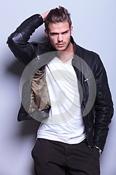 Man in leather jacket passing his hand thorugh his hair photo