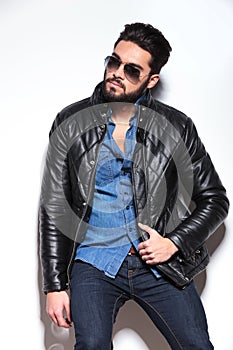 Man in leather jacket and sunglasses looking to his side