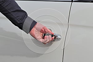 Man left hand locking or unlocking door if a white car