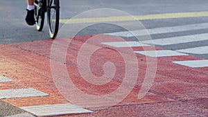 Man legs pedaling city crosswalk red cycling path closeup. Urban traveler riding