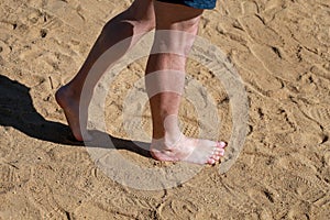 Man legs on sand. Male feet walking on beautiful sandy beach of hotel resort in Egypt, doing and leave footprints in sand.