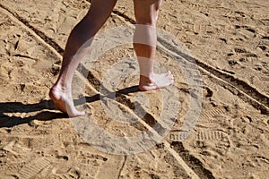 Man legs on sand. Male feet walking on beautiful sandy beach of hotel resort in Egypt, doing and leave footprints in sand.