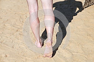 Man legs on sand. Male feet walking on beautiful sandy beach of hotel resort in Egypt, doing and leave footprints in sand.