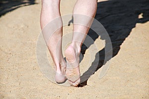 Man legs on sand. Male feet walking on beautiful sandy beach of hotel resort in Egypt, doing and leave footprints in sand.