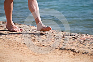 Man legs on sand. Male feet walking on beautiful sandy beach of hotel resort in Egypt, doing and leave footprints in sand.