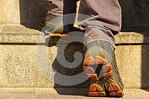 Man legs in the sport shoes in action on stairs outdoors climbing up. Sport and fitness