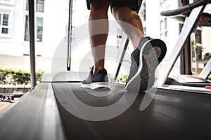 Man legs with sport shoes running on treadmill in fitness gym