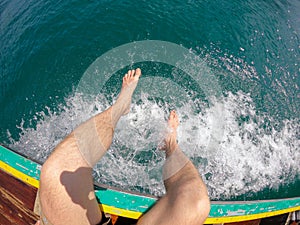 Man legs Tropical Thai jungle lake Cheo lan wood boat, wild mountains nature national park ship yacht rocks