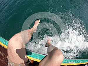 Man legs Tropical Thai jungle lake Cheo lan wood boat, wild mountains nature national park ship yacht rocks