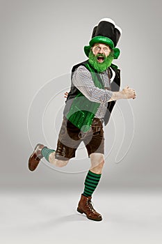 A man in a leprechaun hat at studio. He celebrates St. Patrick`s Day.