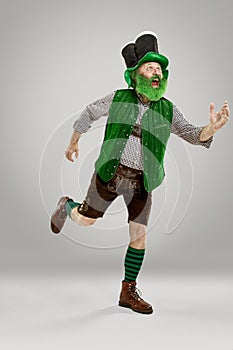 A man in a leprechaun hat at studio. He celebrates St. Patrick`s Day.