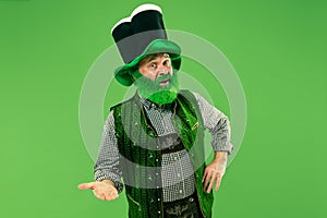 A man in a leprechaun hat at studio. He celebrates St. Patrick`s Day.