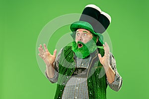 A man in a leprechaun hat at studio. He celebrates St. Patrick`s Day.