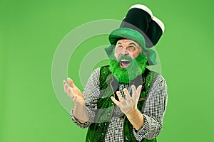 A man in a leprechaun hat at studio. He celebrates St. Patrick`s Day.