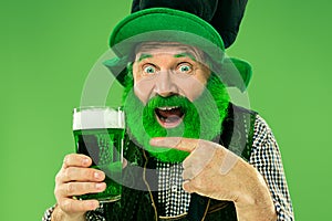 A man in a leprechaun hat at studio. He celebrates St. Patrick`s Day.