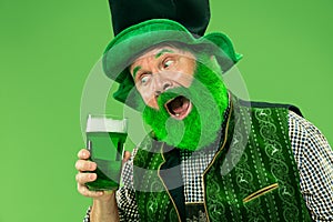 A man in a leprechaun hat at studio. He celebrates St. Patrick`s Day.