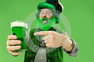 A man in a leprechaun hat at studio. He celebrates St. Patrick`s Day.