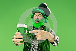 A man in a leprechaun hat at studio. He celebrates St. Patrick`s Day.