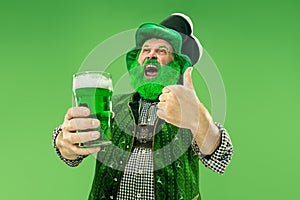 A man in a leprechaun hat at studio. He celebrates St. Patrick`s Day.