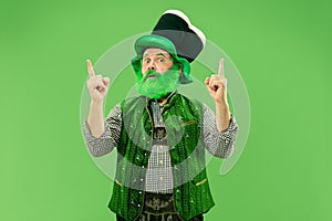 A man in a leprechaun hat at studio. He celebrates St. Patrick`s Day.