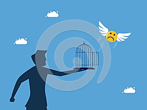 man let the sad face icon fly out of the cage. Liberation of pessimism and freedom