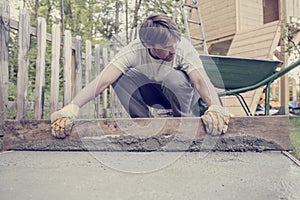 Man leveling the cement in a backyard