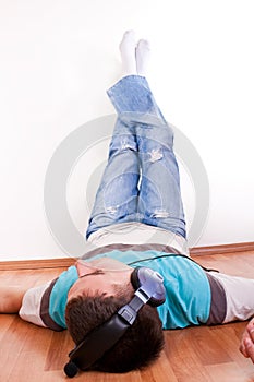 Man lies on the floor with earphones
