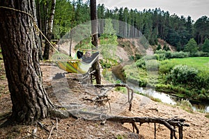 A man lies in a hammock and looks at the landscape.