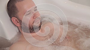 The man lies in a hot therapeutic bath with hydromassage. Spa hotel