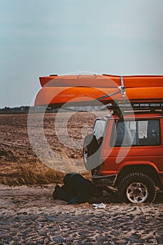 Man lies under a 4x4 car on a dirt road