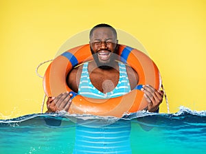 Man with lifebelt is scared to swim. yellow background