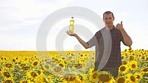 Man lifestyle farmer hand hold bottle of sunflower oil the field at sunset. Sunflower oil improves skin health and