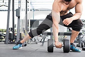 man lift dumbbell in gym. bodybuilder male working out in fitness center. sport guy doing exercises in health club.