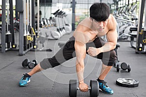 man lift dumbbell in gym. bodybuilder male working out in fitness center. sport guy doing exercises in health club.
